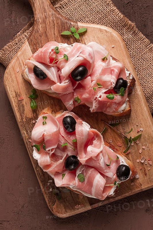 Breakfast, bacon and olives sandwich, on a cutting board, top view, close-up, no people