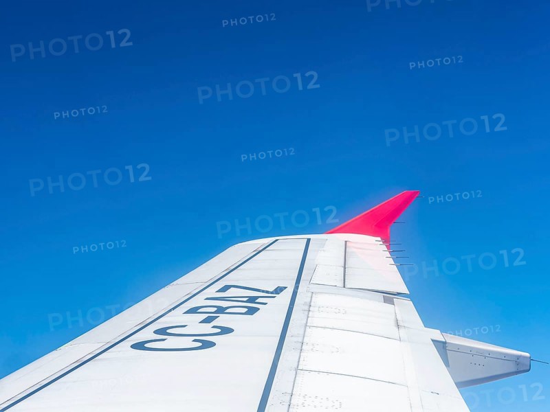 Wing aeroplane with red tip, blue sky