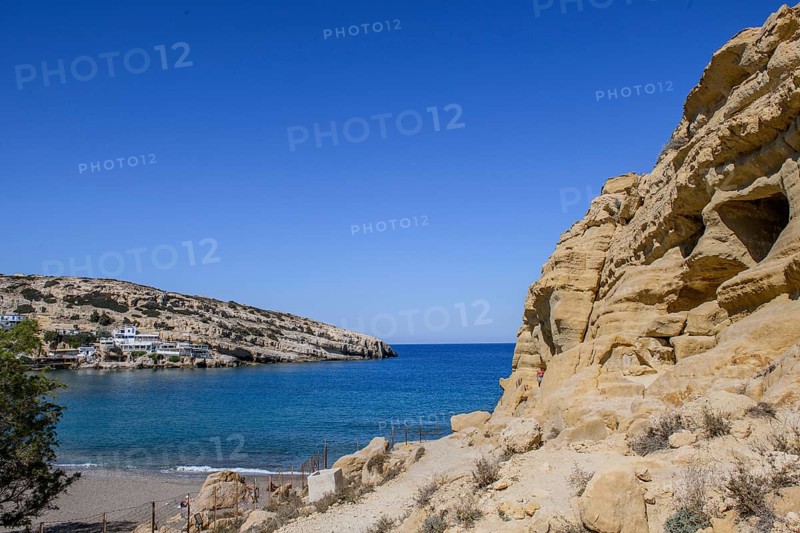 View of partial view of former Roman necropolis with sandstone caves carved into sandstone Cave tombs Grottoes in rocks on the north side of Matala Bay, in the 60s and 70s hippie caves Caves for dropouts and hippies today excursion destination on the south coast of the island of Crete, left at the edge of the picture Libyan Sea Mediterranean Sea, Matala, Crete, Greece, Europe