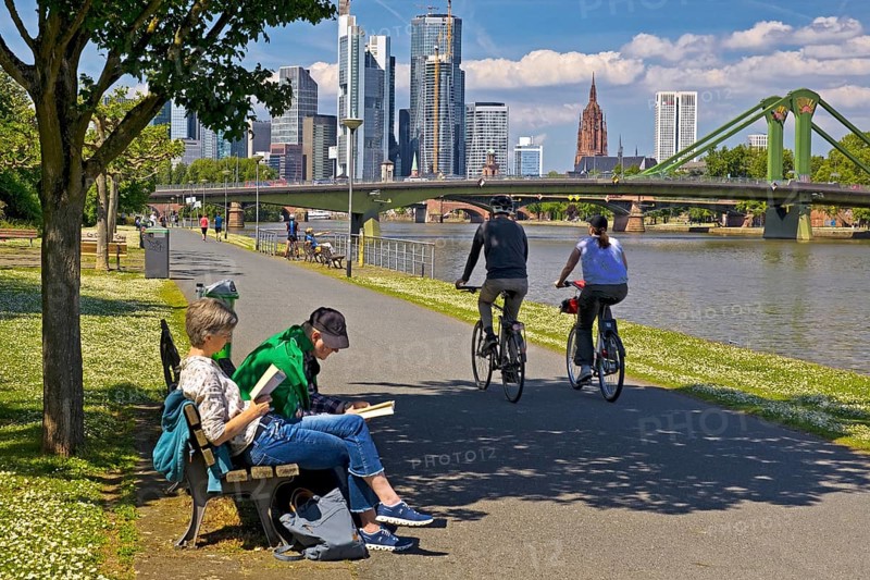 People seeking relaxation in fine weather on the Main promenade in front of the Flößerbrücke, Frankfurt am Main, Hesse, Germany, Europe