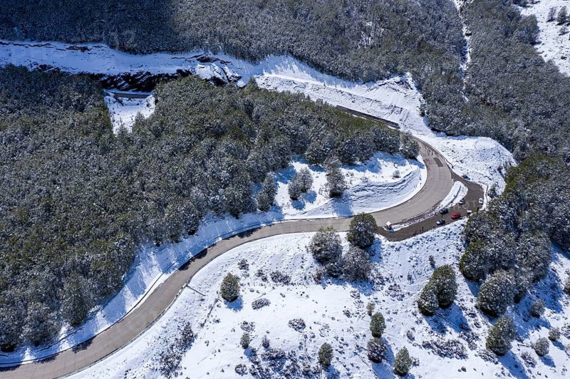 Viewpoint at mountain pass above valley of village Villa Cerro Castillo, aerial view, snow-covered landscape, parking lot at viewpoint, Patagonia, Chile, South America