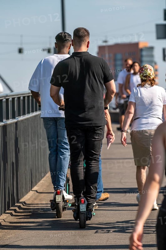 Pedestrians and e-scooters on a pavement, getting close and in each other's way, illegal driving on the pavement by e-scooter users, Düsseldorf, North Rhine-Westphalia