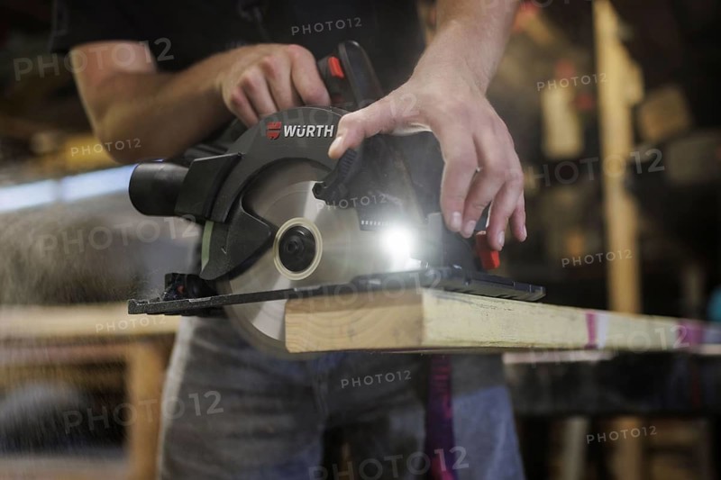 A man cuts wood with a hand-held circular saw. Berlin, 14.08.2024