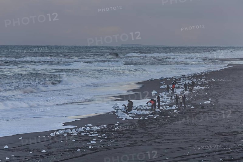 Tourists photographing ice floes on the beach, waves, sea, clouds, winter, Diamond Beach, Breidamerkursandur, Jökulsarlon, Iceland, Europe