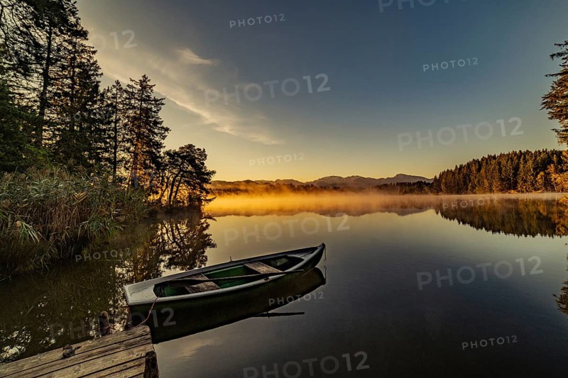 Boats in the autumnal Schmutter Weiher in the Allgäu near the municipalities of Halblech, Roßhaupten and Lechbruck in Ostallgäu in the foothills of the Alps