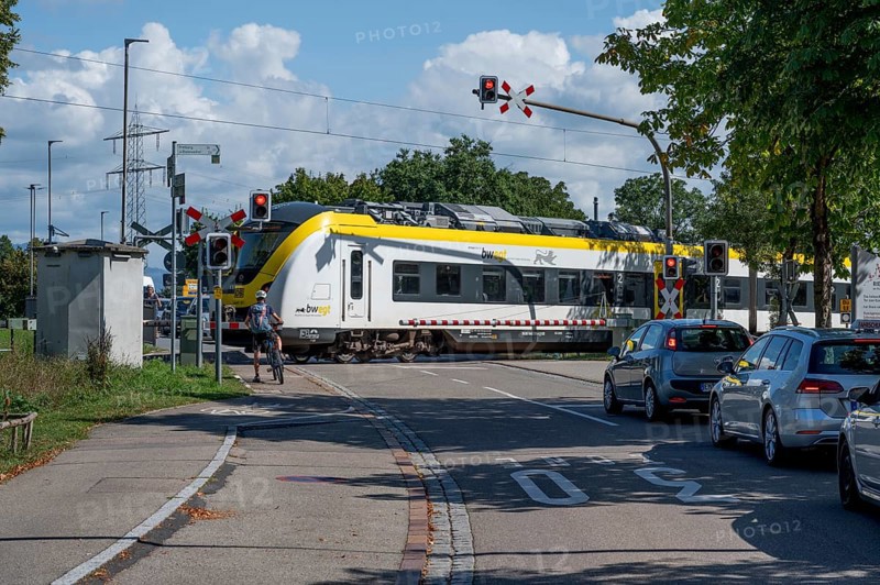 Regional train crossing a level crossing with barriers, Riegel am Kaiserstuhl, Baden-Württemberg, Germany, Europe