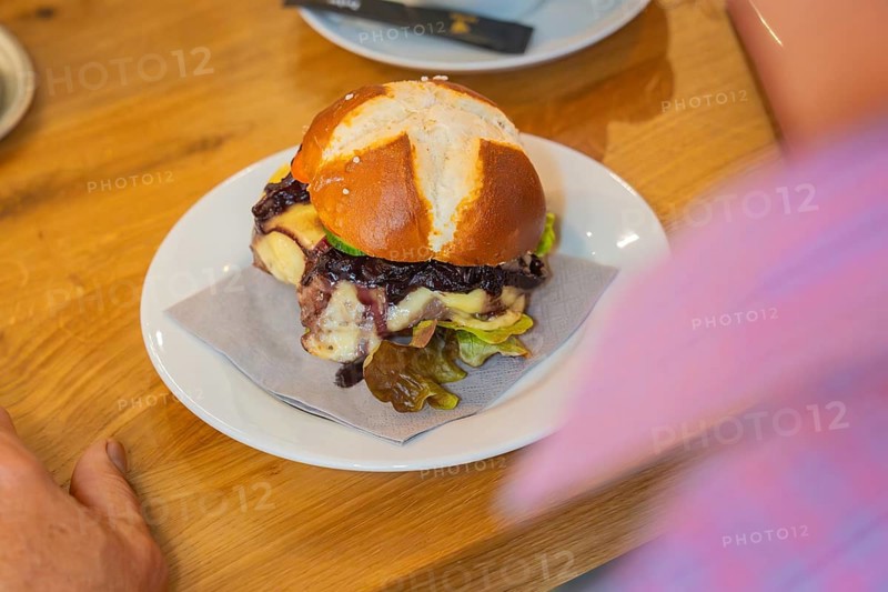 Close-up of a burger on a pretzel bun on a plate, autumn creations, Cafe Kuh, Deckenpfronn, Black Forest, Germany, Europe