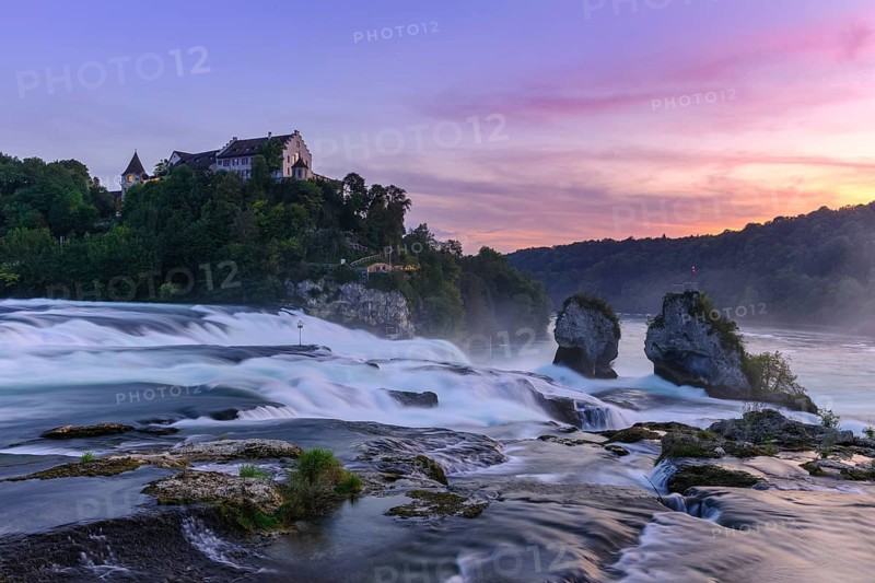 Fascinating view of a waterfall with a castle on a cliff at sunset, Schloss Laufen, Rhine Falls, Canton Schaffhausen, Switzerland, Europe