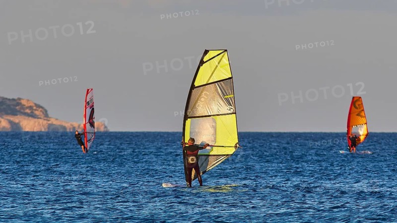 Windsurfer with coloured sail on the blue sea, windsurfer, Meltemi windsurfing spot, Devils Bay, Paralia Vatha, Vatha Beach, southeast coast, Karpathos, Dodecanese, Greek Islands, Greece, Europe