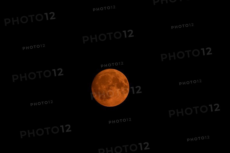 Full super moon red orange in colour in the night sky, Suffolk, England, United Kingdom, Europe