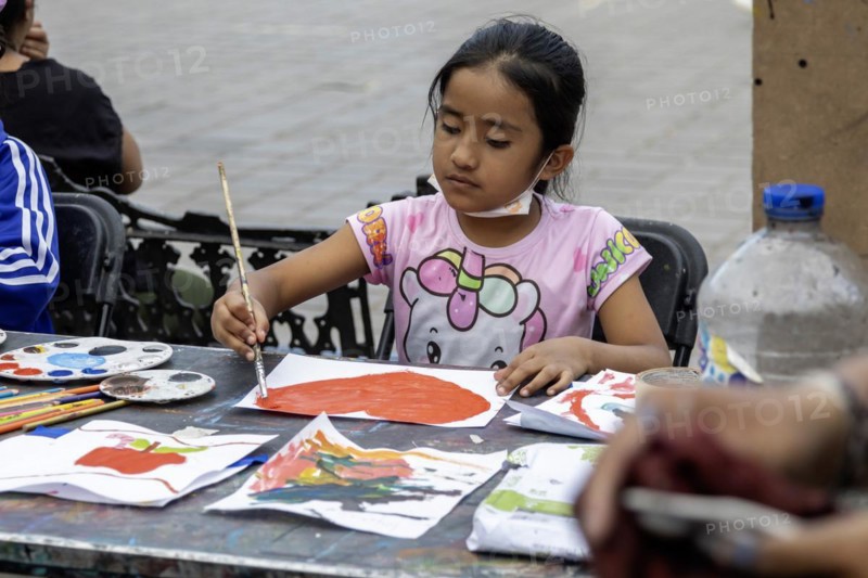 Oaxaca, Mexico, Students painting at a temporary art class in the zocalo. A girl paints a heart the day before Valentine's Day, Central America