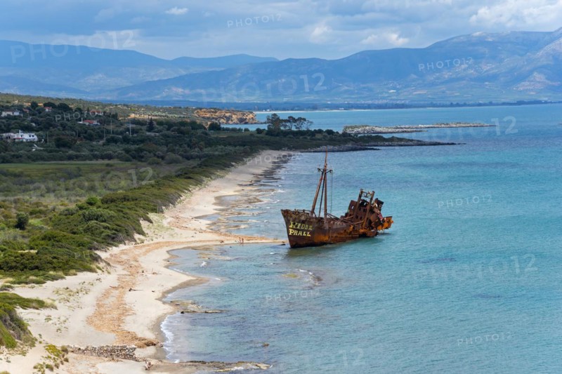 Old shipwreck on a sunny beach with a view of the sea and distant mountains, Dimitrios shipwreck, Glyfada beach, Selinitsa, Gythio, Githio, Gythion, Mani, Laconia, Peloponnese, Greece, Europe