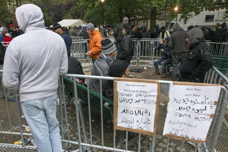 Refugees from Syria waiting to be registered at the Central Reception Centre for Asylum Seekers at the Berlin State Office for Health and Social Affairs, signs indicating waiting numbers, 09/10/2015
