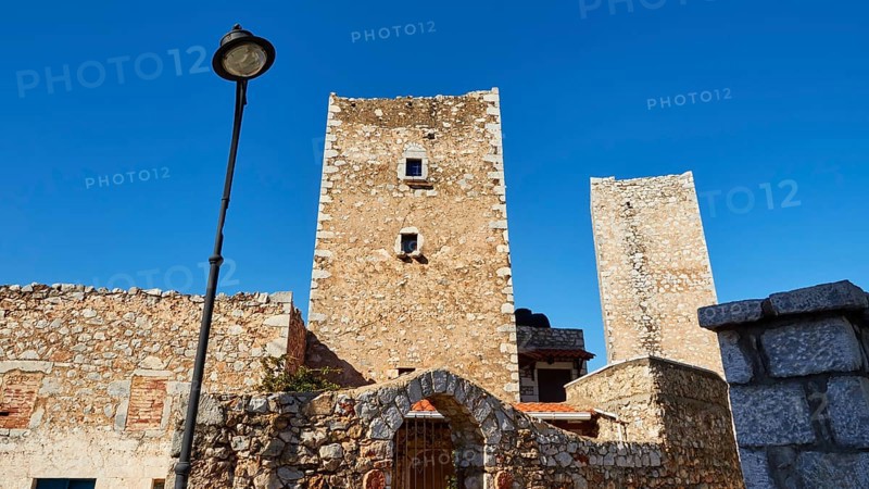 Historic stone towers next to a street lamp in a Mediterranean village, Flomochori, residential towers village, Mani peninsula, Peloponnese, Greece, Europe