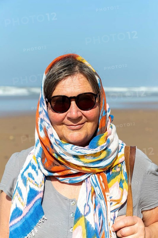 Middle aged woman on beach with sunglasses and head scarf, Morocco, north Africa, Model Released, Africa