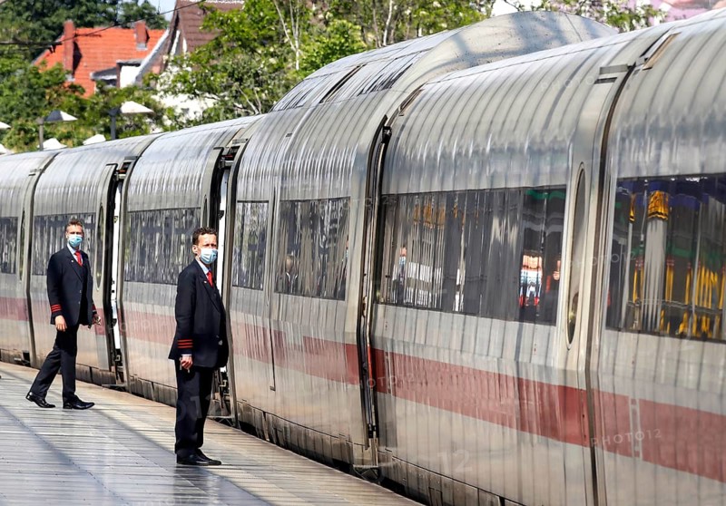 Deutsche Bahn train attendants wear face masks shortly in front of the departure of an ICE train at Berlin Spandau station, 27/05/2020