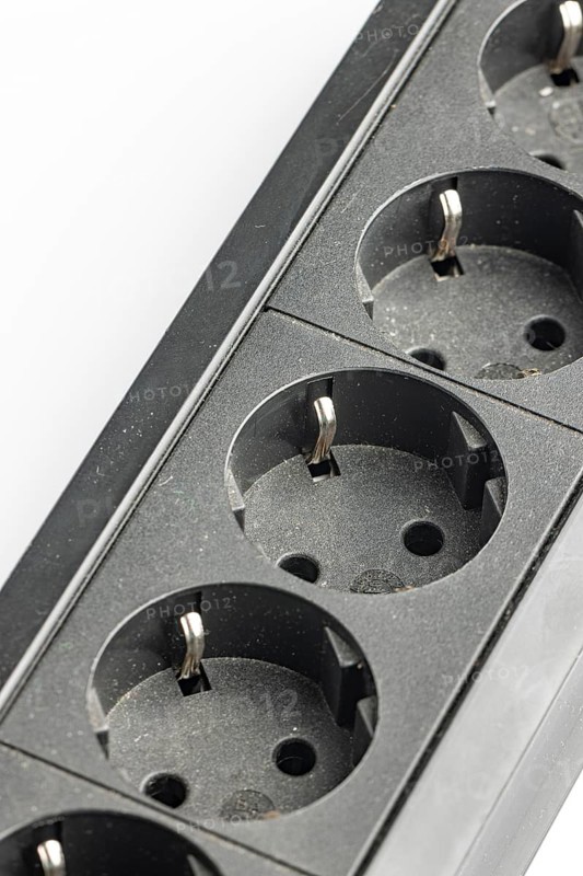 Part of a black plastic socket strip with empty sockets