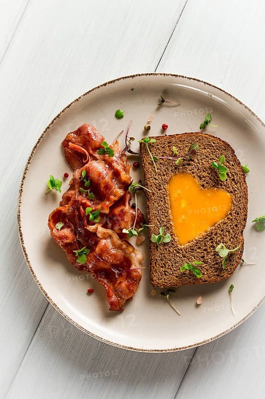 Breakfast, fried egg with bacon, micro-green, on a light background, no people, selective focus