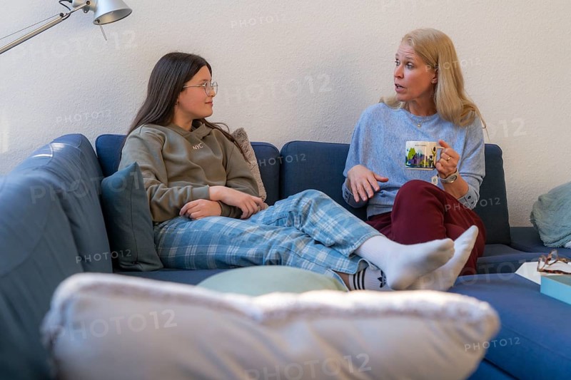 Mother and daughter, teenage, 13 years old, in a confidential conversation, at home