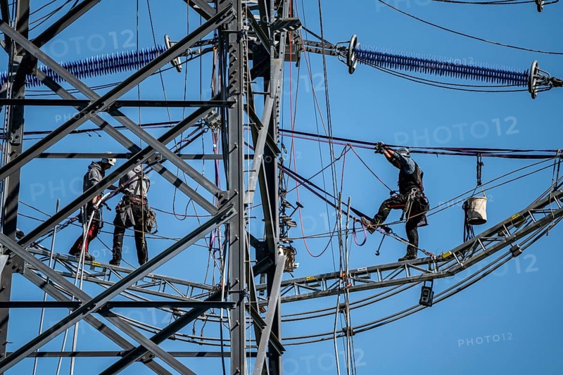 Construction of a new line route, 380 KV extra-high voltage line between Osterath and Gohr, near Neuss, fitter on a boom of an electricity pylon, at great height, North Rhine-Westphalia, Germany, Europe