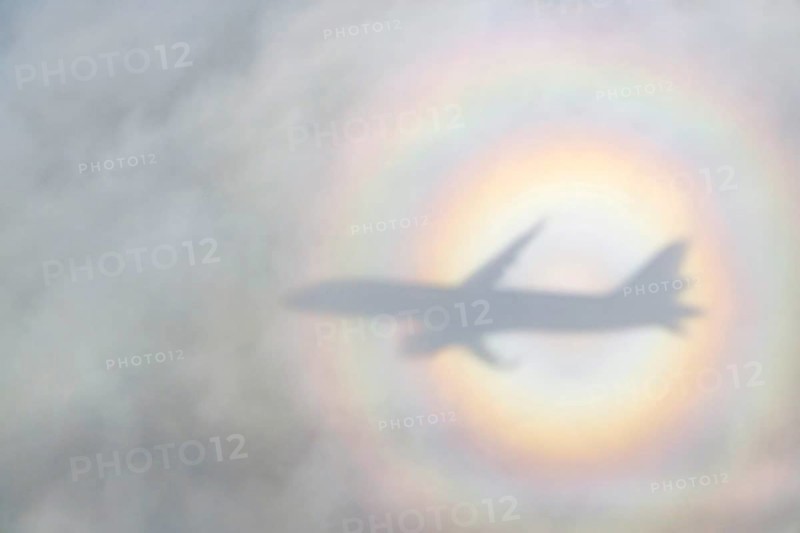 An aeroplane casts a shadow on a cloud, silhouette, halo rainbow. Germany