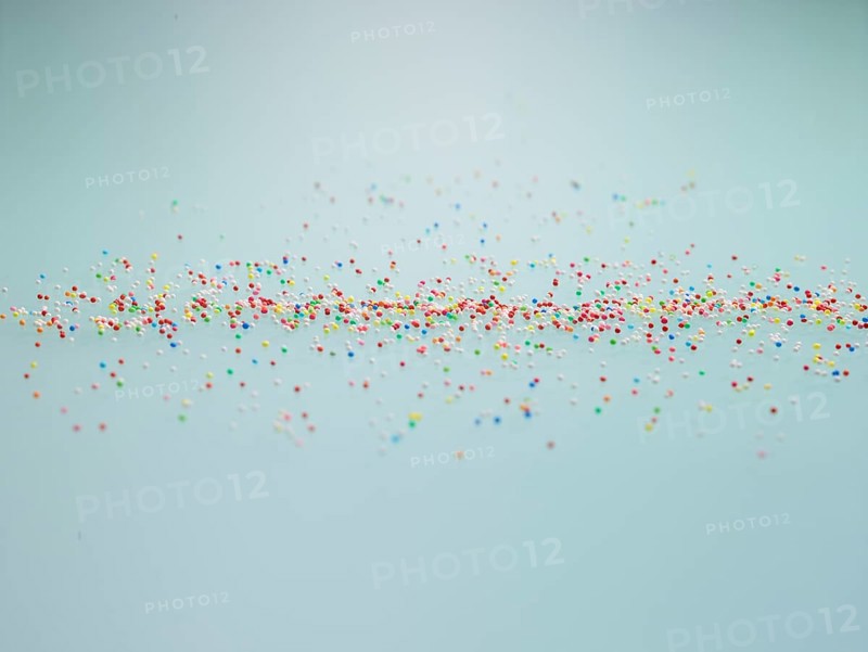 Colourful nonpareils, sugar pearls, sprinkle decorations in bright colours, mini sugar balls for decorating ice cream, cakes and muffins, studio shot