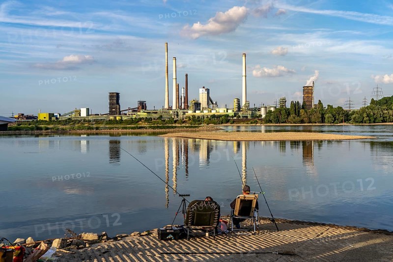 Industrial backdrop of the ThyssenKrupp Steel steelworks in Bruckhausen, on the Rhine, Schwelgern coking plant, anglers in a bay in the Rhine near Duisburg Bärl, Duisburg, North Rhine-Westphalia, Germany, Europe