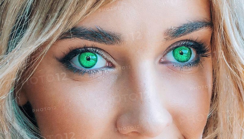Close-up of a female face with bright green eyes and blonde hair, strong gaze, AI generated, AI generated