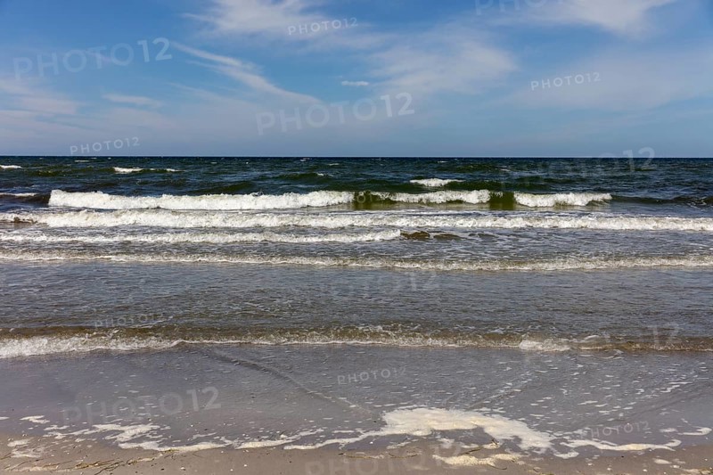 Foamy waves crash onto the coast in sunny weather and blue skies, Rügen, Hiddensee