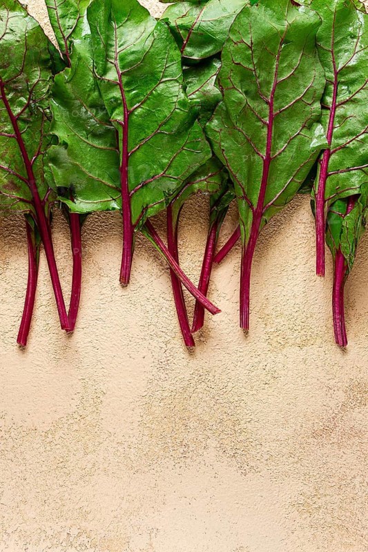 Fresh, green leaves, stem with beet leaves, on the table, top view, rustic, no people
