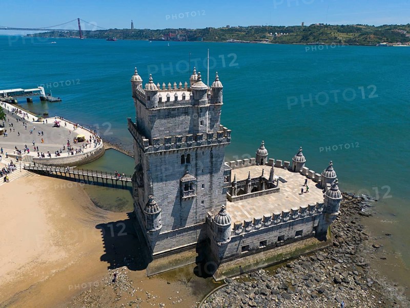 A historic tower on a rocky shore with blue water and sky in the background, aerial view, Torre de Belém, World Heritage Site, Belem, Bethlehem, Lisbon, Lisboa, River Tagus, Portugal, Europe