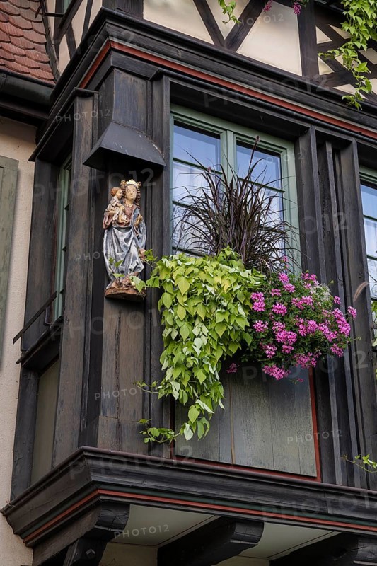 Decorative floral decoration with a statue of the Virgin Mary on a historic half-timbered house in the old town of Gengenbach, Ortenaukreis, Baden-Württemberg, Germany, Europe