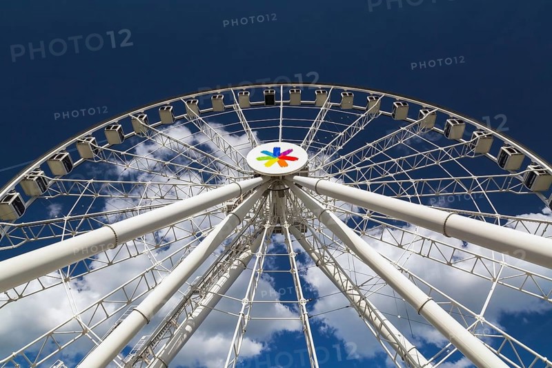 The Montreal Observation Ferris Wheel or La Grande Roue de Montreal amusement ride decorated with the symbolic LGBTQ+ rainbow flag colours, Old Port of Montreal, Quebec, Canada. George Ferris (1859–96), is the American engineer who invented the ferris wheel
