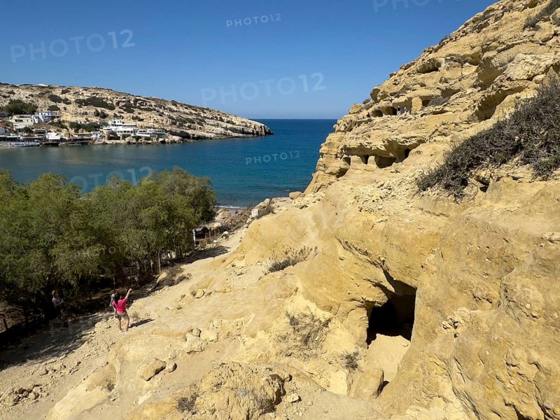 View of entrances of caves in sandstone rocks of former Roman necropolis with sandstone caves carved into sandstone Cave tombs Grottoes in rocks on the north side of Matala Bay, in the 60s and 70s hippie caves Caves for dropouts and hippies today excursion destination on the south coast of Crete island, left at the edge of the picture Libyan Sea Mediterranean, Matala, Crete, Greece, Europe