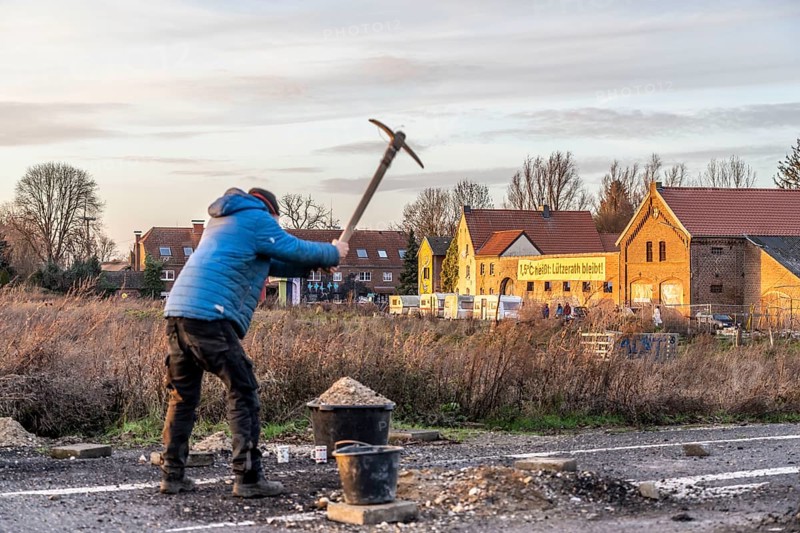 Climate activists chop up the asphalt of a road to erect obstacles, barricades, to prevent the police from evicting the occupied hamlet of Lützerath, the remains of the village are to make way for lignite mining, an eviction is imminent, North Rhine-Westphalia, Germany, Europe