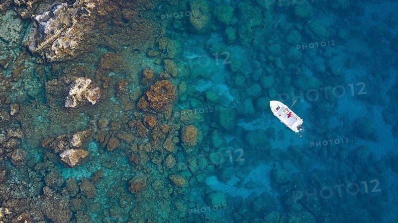 Drone shot, boat in crystal clear blue water between rocks and corals, Anthony Quinn Bay, Vagies Bay, Rhodes, Dodecanese, Greek Islands, Greece, Europe