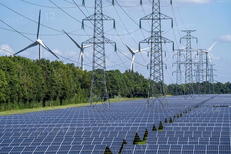 High-voltage power line route, the space underneath is used for a solar park over 5 km long, behind it a wind farm, in the harbour area of Vlissingen-Oost, Netherlands
