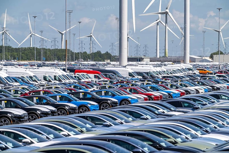 Storage area for new cars in the port of Vlissingen-Oost, vehicles are temporarily stored on over 100 hectares to ship them from Europe to the United Kingdom, Ford cars, others such as models from the Chinese car manufacturer BYD are delivered from here in Europe, wind farm, Netherlands