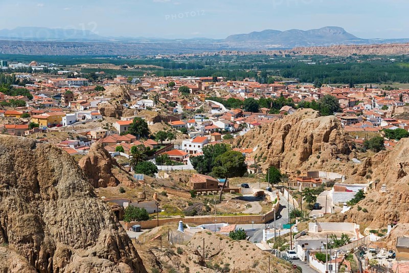 Panorama of a town with red roofs in a mountainous landscape under a blue sky, view from the Mirador del Cerro de la Bala, cave dwellings, cave district, Troglodytos, Barrio de Cuevas, Guadix, Granada province, Andalusia, Spain, Europe