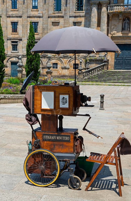 Old camera on wheels with umbrella on a cobblestone square, camera, Santiago de Compostela, autonomous community of Galicia, place of pilgrimage, destination of the Way of St James, Spain, Europe