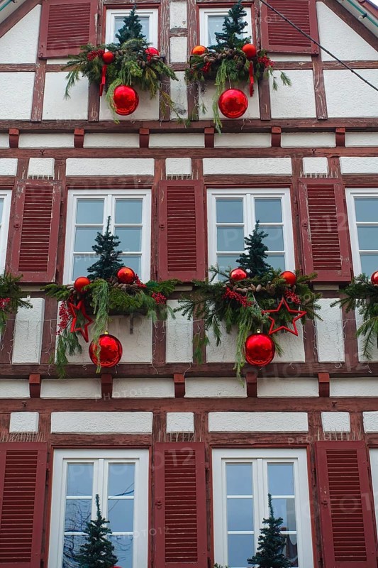 House facade with Christmas decoration, window, window shutters, half-timbered, Christmas motif, Christmas, Christmas festival, Advent season, red Christmas baubles, stars, firs, pine cones, conifer, fir branches, jewellery, Advent season, Christmas card motif, half-timbered house, Berger bakery, Reutlingen, Baden-Württemberg, Germany, Europe