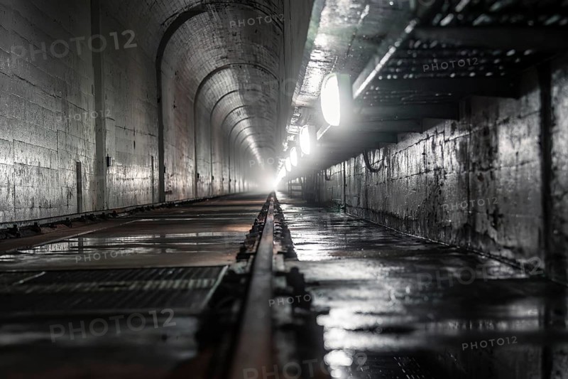 Dark tunnel with wet concrete walls and light at the end, industrial atmosphere, Rappbodetalsperre, Harz Mountains, Germany, Europe