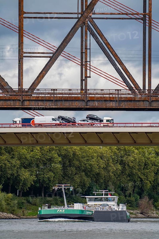 The Beeckerwerth Rhine bridge of the A42 motorway, truck traffic, in front of it the Haus-Knipp railway bridge, cargo ship on the Rhine near Duisburg, North Rhine-Westphalia, Germany, Europe