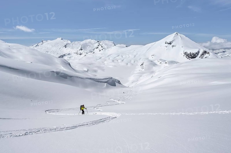 Lone ski tourer in mountain landscape with snow, summit Mittaghorn and Wildhorn, ascent to Wildstrubelhütte, Bernese Alps, Switzerland, Europe