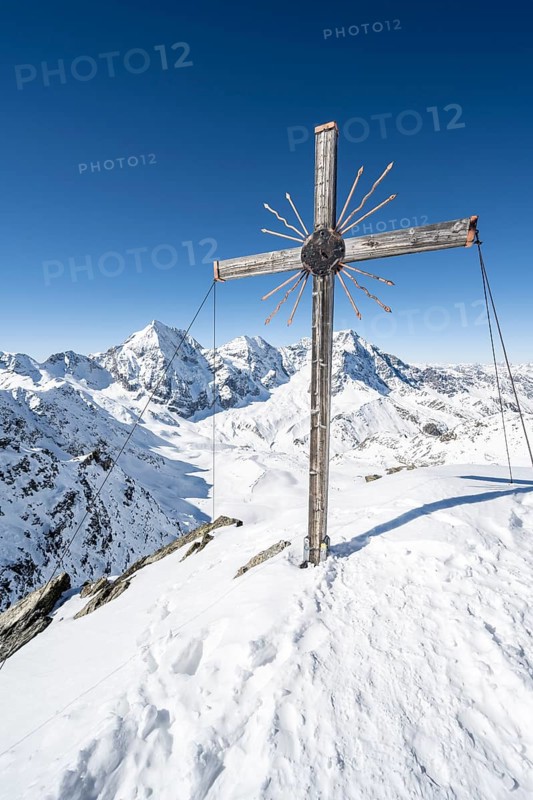 Summit cross at the summit of the Madritschspitze, mountain panorama with snow-covered mountain landscape in winter, view of mountain peaks Königsspitze, Monte Zebru and Ortler, Ortler Alps, Vinschgau Valley, Italy, Europe