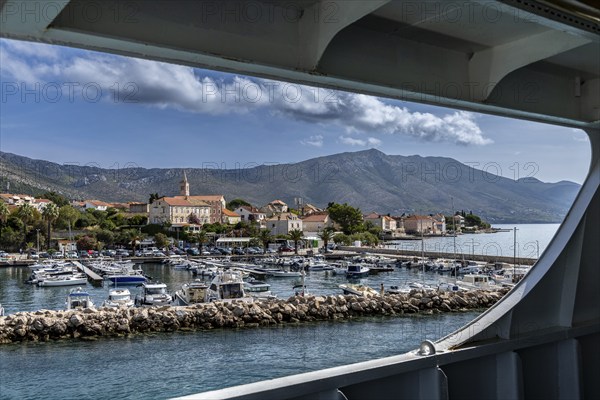 View from a window of a ship to a harbour with boats, surrounded by a mountain village and the coast, Peljesac, Croatia, Europe