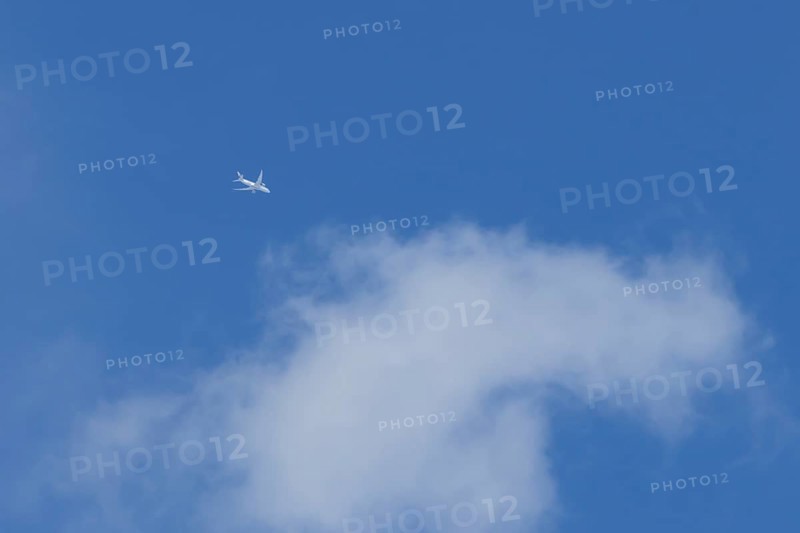 Boeing 787-8 Dreamliner jet aircraft of Qatar airlines flying in a blue sky with a white cloud, England, United Kingdom, Europe