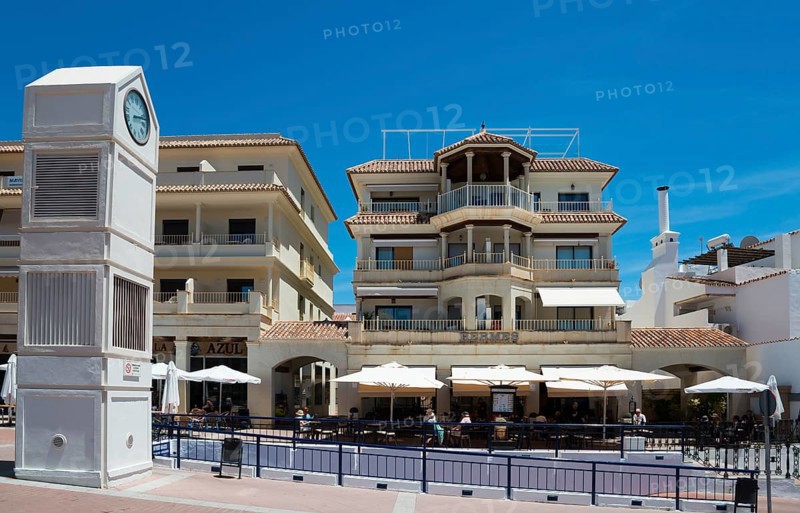 Clock tower and Mediterranean buildings with balconies and cafés in sunny weather, Plaza de España, Nerja, Málaga province, Malaga, Costa del Sol, Andalucia, Spain, Europe