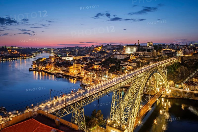 View of illuminated Porto city and Douro river and Dom Luis bridge I from famous tourist viewpoint Miradouro da Serra do Pilar in evening twilight. Porto, Vila Nova de Gaia, Portugal, Europe
