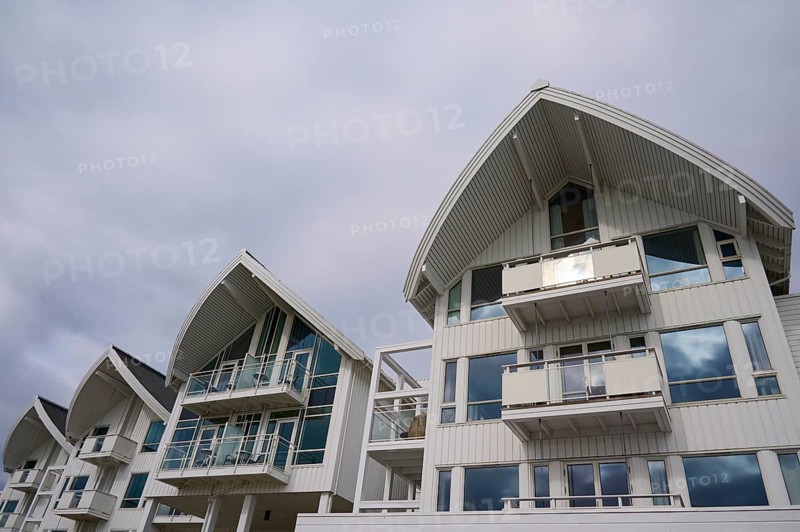 A modern residential building with several balconies and glass fronts under a cloudy sky, Molde, Romsdal, Norway, Europe